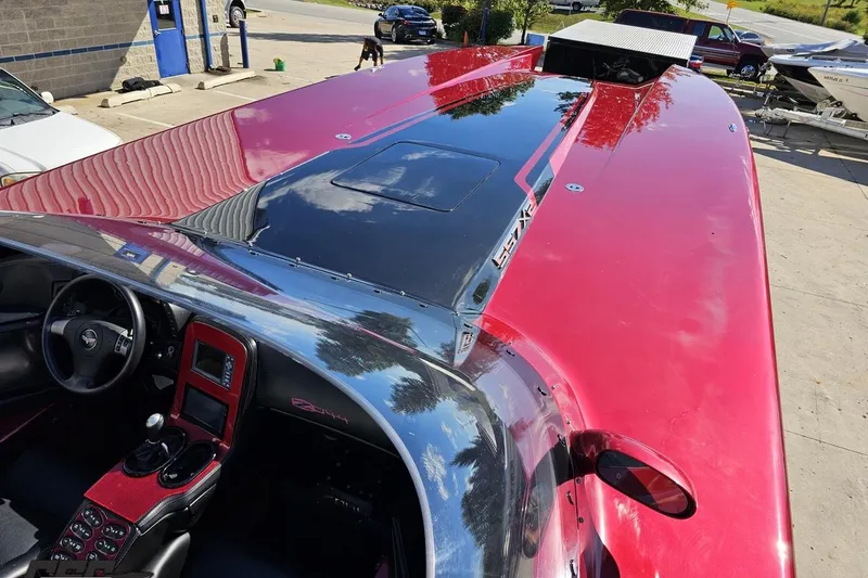 Slide: The Image of 2010 MTI 44 Corvette boat with sleek red and black design, parked outdoors. - 63