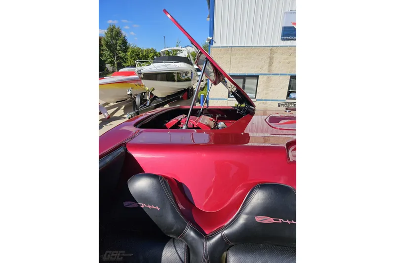 Slide: The Image of Red 2010 MTI 44 Corvette boat with open engine compartment, parked near other boats. - 89