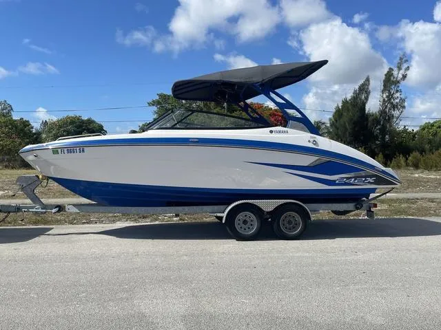 Slide: The Image of 2020 Yamaha Boats 242X on trailer, blue and white, side view. - 3