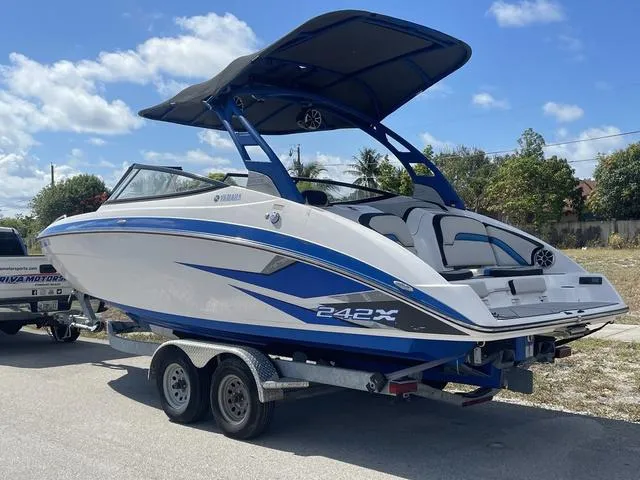 Slide: The Image of 2020 Yamaha Boats 242X on trailer, blue and white, with bimini top. - 5