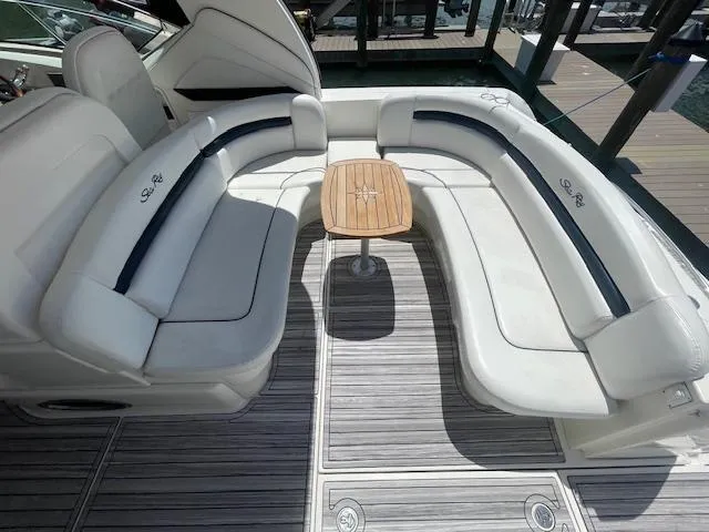 Slide: The Image of 2005 Sea Ray 390 Sundancer cockpit with white seating and wooden table. - 10