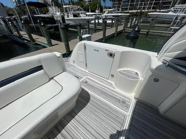 Slide: The Image of 2005 Sea Ray 390 Sundancer boat interior at marina, featuring white seating and deck. - 11