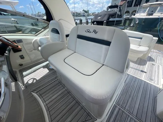 Slide: The Image of 2005 Sea Ray 390 Sundancer interior with white seating and marina view. - 12