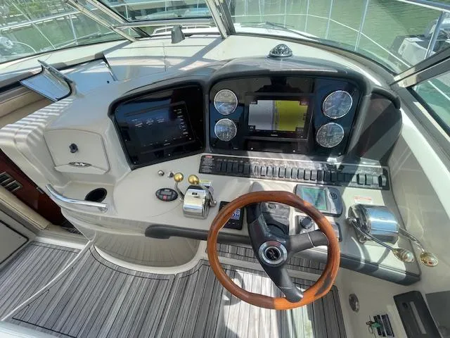 Slide: The Image of Helm of 2005 Sea Ray 390 Sundancer with modern navigation instruments and wooden steering wheel. - 26