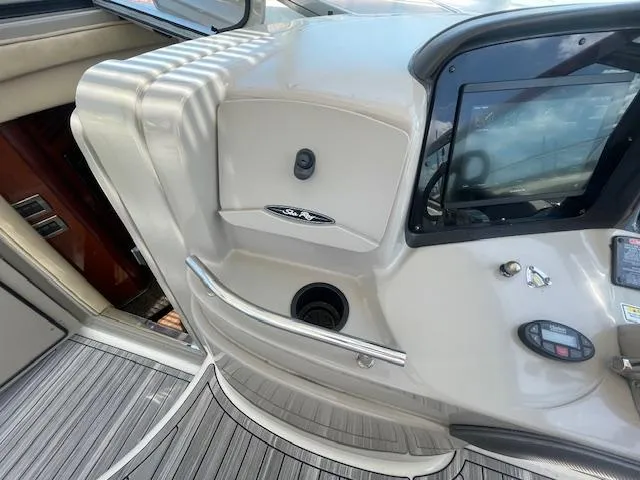 Slide: The Image of 2005 Sea Ray 390 Sundancer helm station with control panel and cup holder. - 29