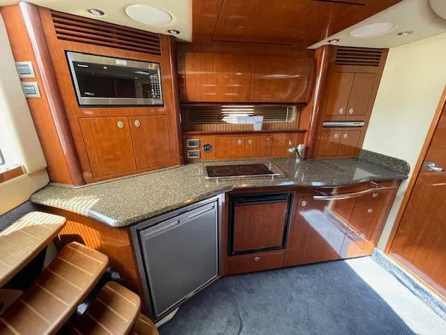 Slide: The Image of 2005 Sea Ray 390 Sundancer kitchen with wood cabinetry and modern appliances. - 33