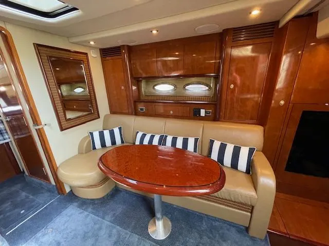 Slide: The Image of Interior of 2005 Sea Ray 390 Sundancer with leather seating and wooden table. - 34