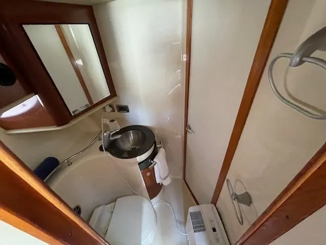 Slide: The Image of Compact bathroom in 2005 Sea Ray 390 Sundancer yacht with sink, mirror, and toilet. - 35