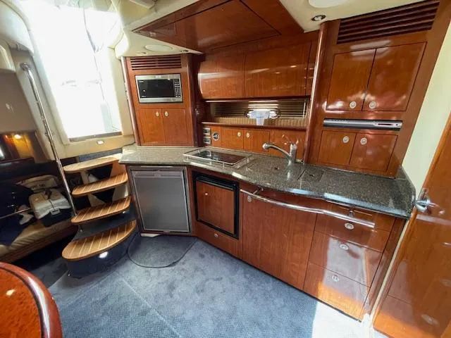 Slide: The Image of 2005 Sea Ray 390 Sundancer kitchen with wooden cabinetry, granite countertops, and modern appliances. - 37