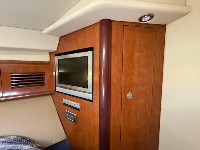 Slide: The Image of Interior cabin of 2005 Sea Ray 390 Sundancer with TV and wooden cabinetry. - 43