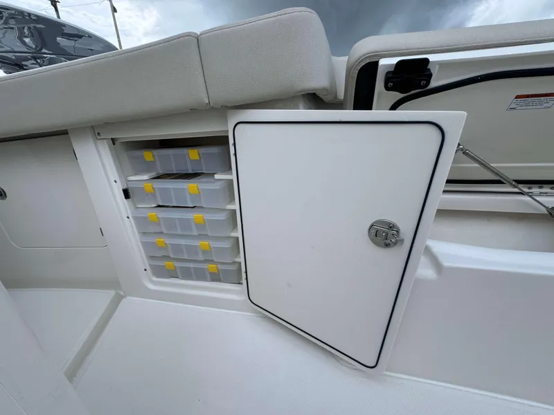 Slide: The Image of Storage compartment with tackle boxes on a 2024 Solace 32 CS boat. - 12