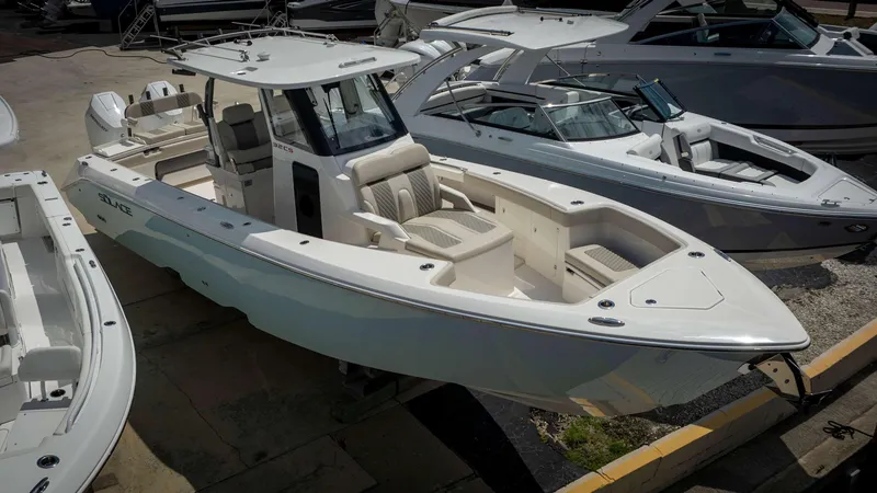 Slide: The Image of 2024 Solace 32 CS boat in a marina, showcasing sleek design and spacious seating. - 3