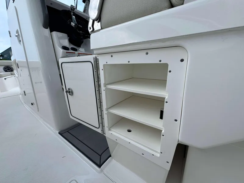 Slide: The Image of 2024 Solace 32 CS boat interior storage compartments and control panel. - 30