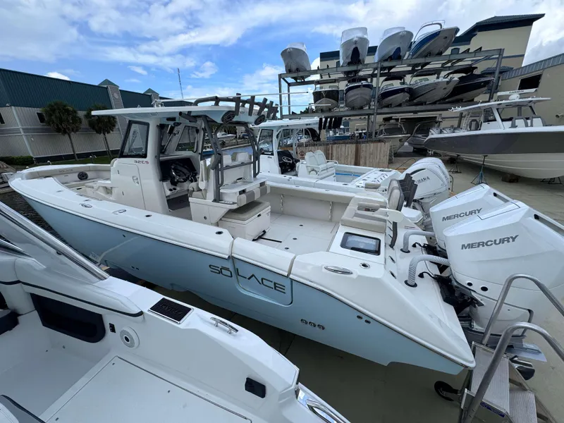 Slide: The Image of 2024 Solace 32 CS boat with twin Mercury engines docked at a marina. - 4