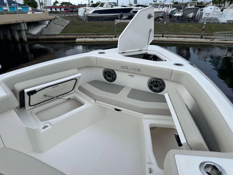 Slide: The Image of 2024 Solace 32 CS boat interior with seating, storage compartments, and speakers. - 7