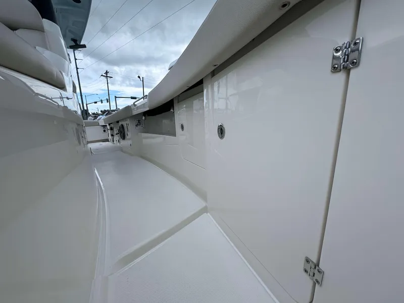 Slide: The Image of 2024 Solace 32 CS boat interior walkway with storage compartments. - 9