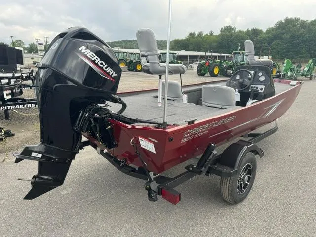 Slide: The Image of 2024 Crestliner 1600 Storm fishing boat with Mercury outboard motor, parked on a trailer. - 5