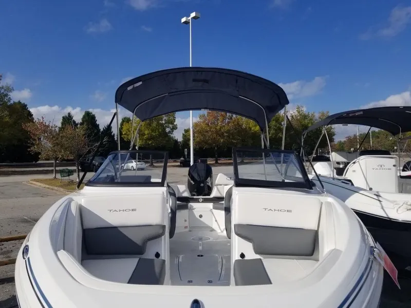 Slide: The Image of 2024 Tahoe 210 S boat with canopy, parked outdoors under a clear blue sky. - 5