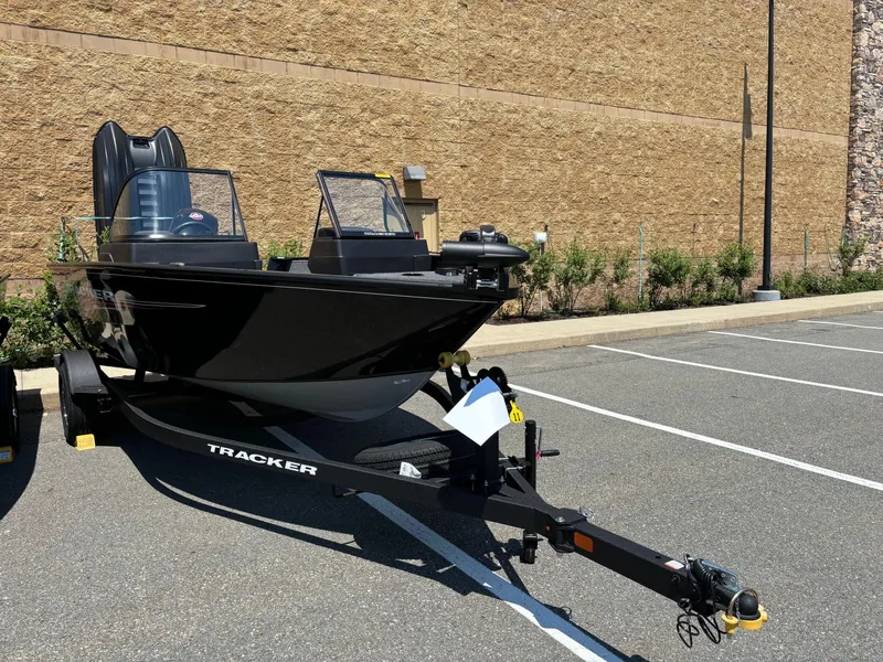 Slide: The Image of 2024 Tracker Pro Guide V-175 WT boat on a trailer in a parking lot. - 2
