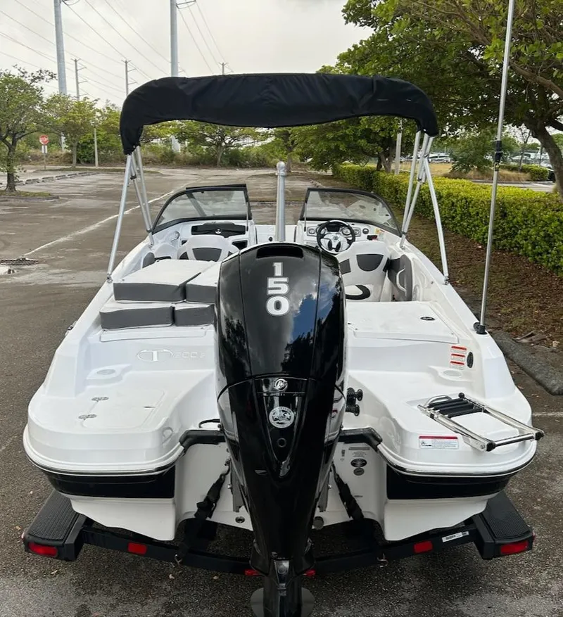 Slide: The Image of 2024 Tahoe 200 S boat with black outboard motor and canopy in parking lot. - 3