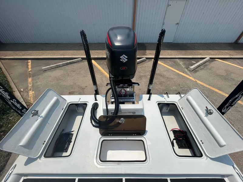 Slide: The Image of 2025 Shallow Stalker 240 RC Elite boat with open storage compartments and Suzuki outboard motor. - 16
