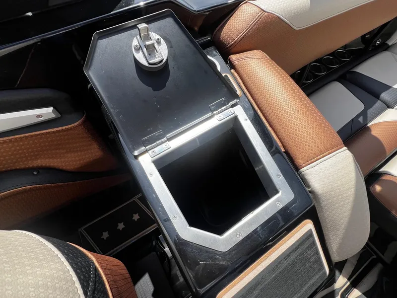 Slide: The Image of Open storage compartment in 2021 Centurion Ri245 boat with brown and beige seats. - 31