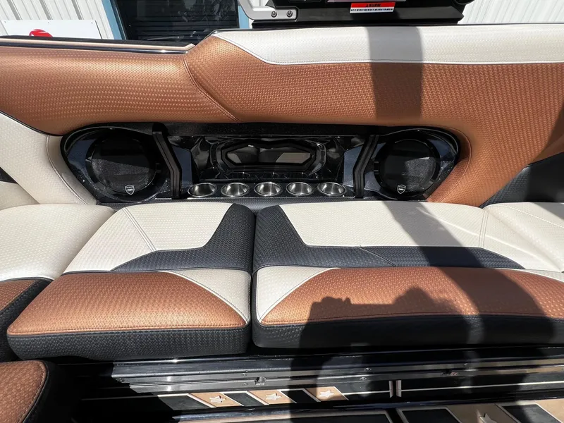 Slide: The Image of 2021 Centurion Ri245 boat interior with brown, black, and white seating and built-in speakers. - 41