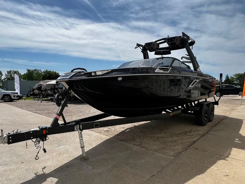 Slide: The Image of 2021 Centurion Ri245 boat on a trailer under a partly cloudy sky. - 6