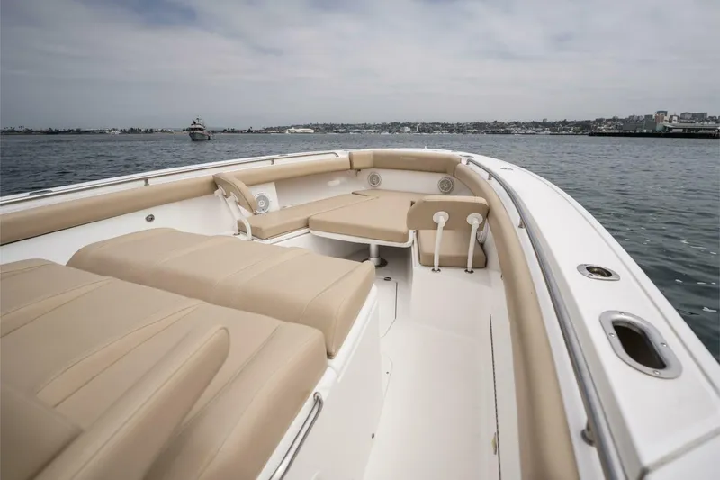 Slide: The Image of 2019 Everglades 435 Center Console boat with beige seating on calm water. - 10