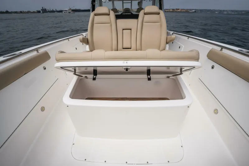 Slide: The Image of 2019 Everglades 435 Center Console boat with open storage compartment and beige seating. - 12