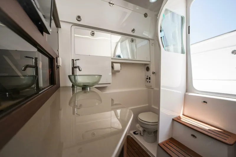 Slide: The Image of 2019 Everglades 435 Center Console boat bathroom with modern fixtures and glass sink. - 15