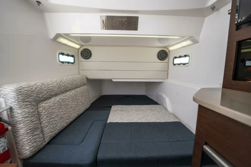 Slide: The Image of 2019 Everglades 435 Center Console cabin interior with cushioned seating and small windows. - 17