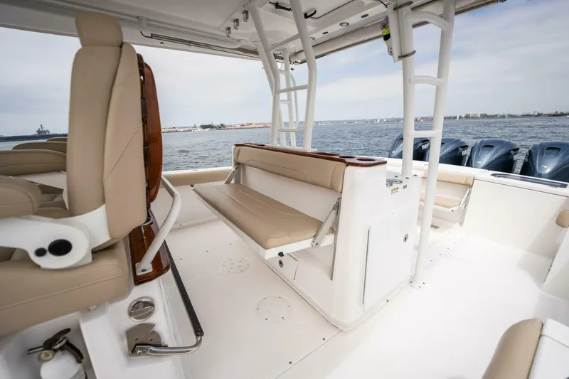 Slide: The Image of 2019 Everglades 435 Center Console boat interior with beige seating and ocean view. - 24