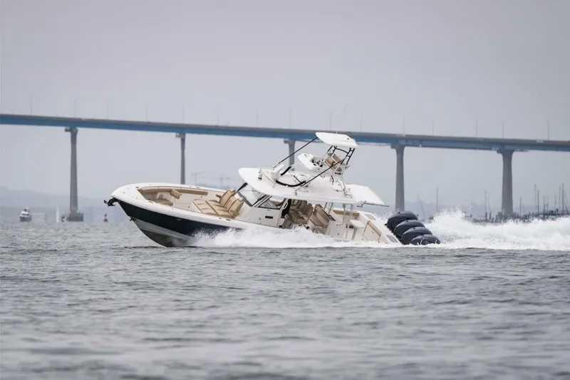 Slide: The Image of 2019 Everglades 435 Center Console boat cruising on water near a bridge. - 7
