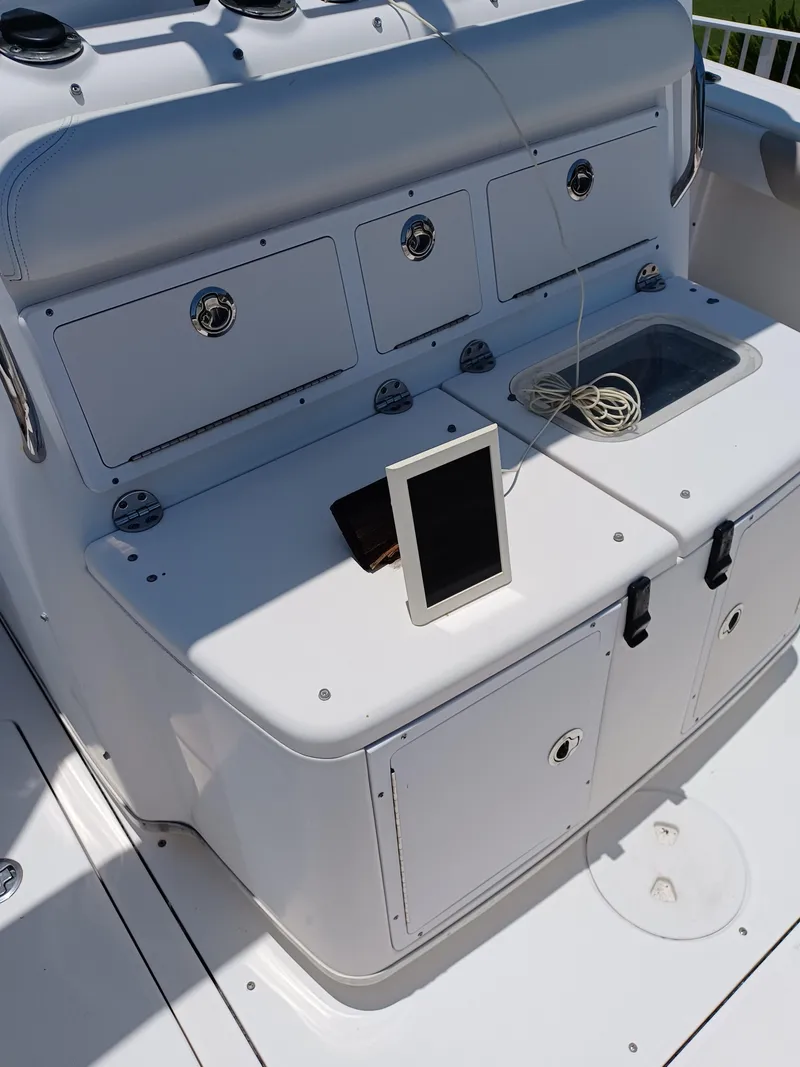 Slide: The Image of 2016 Robalo R300 Center Console boat with storage compartments and tablet on deck. - 12