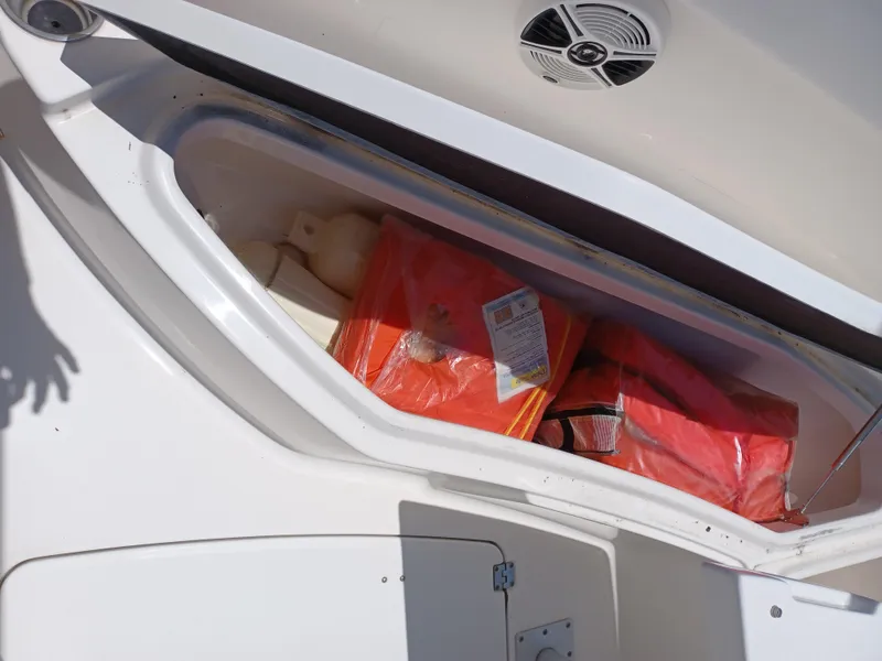Slide: The Image of Storage compartment on a 2016 Robalo R300 Center Console boat with life jackets. - 16