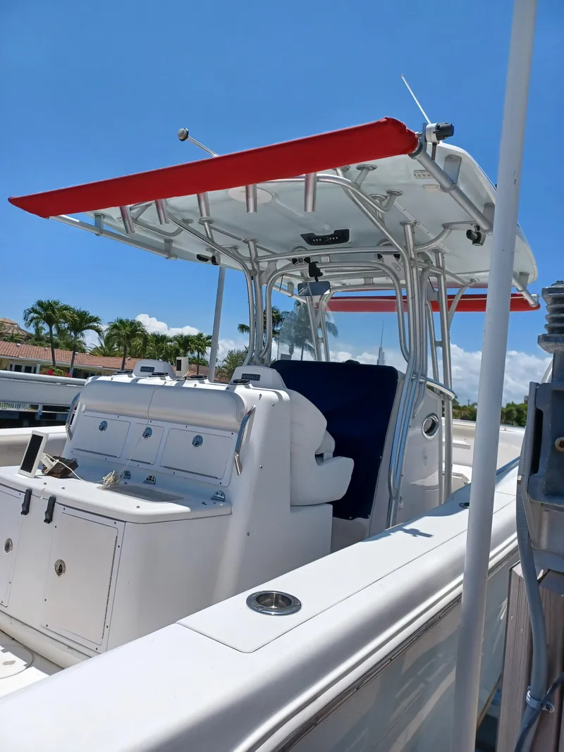 Slide: The Image of 2016 Robalo R300 Center Console boat with red canopy and white seating. - 5