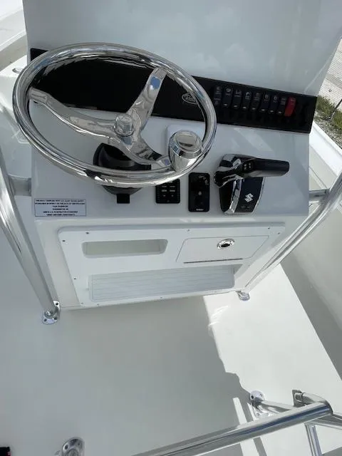 Slide: The Image of Pair Customs 21MV 2025 boat control console with steering wheel and throttle. - 18