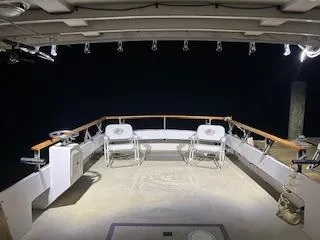Slide: The Image of 1989 Markley 35 Ft. Deadrise boat deck at night, featuring seating and railing. - 15
