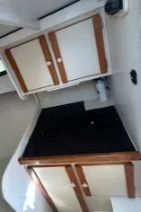 Slide: The Image of 1989 Markley 35 Ft. Deadrise boat interior with wooden cabinets and black countertop. - 16