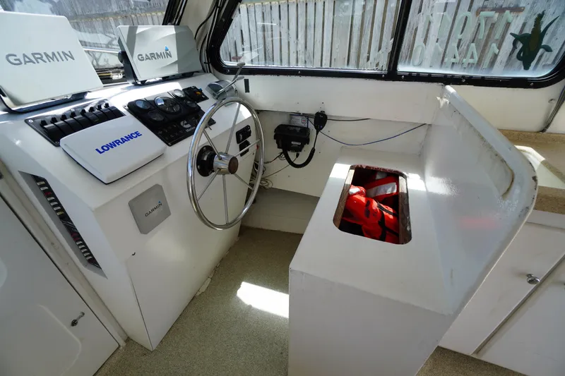 Slide: The Image of 1989 Markley 35 Ft. Deadrise boat cockpit with Garmin and Lowrance navigation systems. - 24