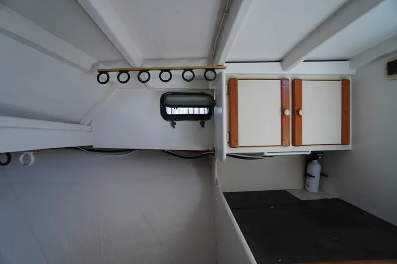 Slide: The Image of Interior of 1989 Markley 35 Ft. Deadrise boat with cabinets and porthole. - 39