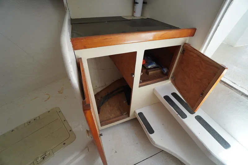 Slide: The Image of Interior of 1989 Markley 35 Ft. Deadrise boat showing open wooden cabinets and steps. - 42