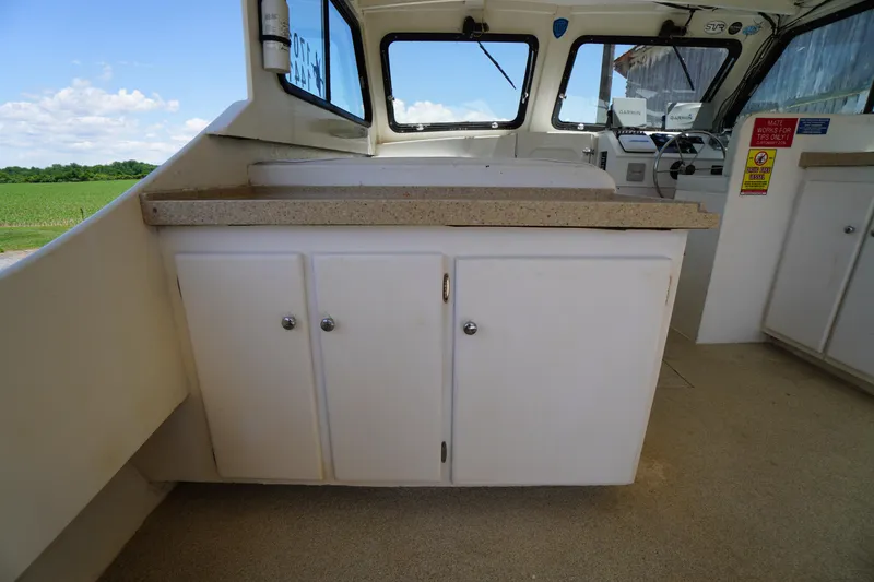 Slide: The Image of Interior view of a 1989 Markley 35 Ft. Deadrise boat with cabinets and windows. - 48