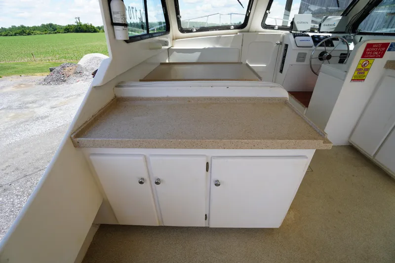 Slide: The Image of Interior of 1989 Markley 35 Ft. Deadrise boat with countertop and steering area. - 49