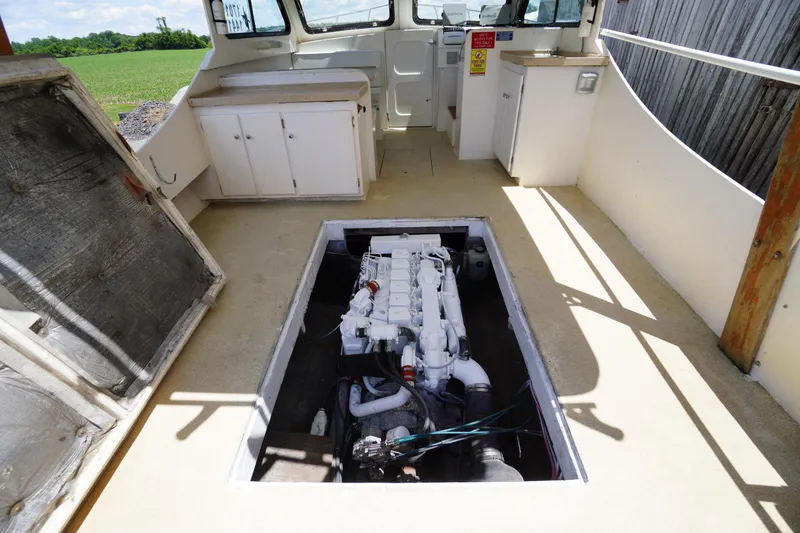Slide: The Image of 1989 Markley 35 Ft. Deadrise boat interior with exposed engine and cabinetry. - 55