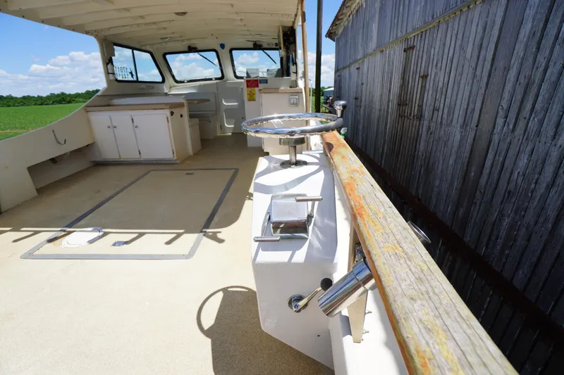 Slide: The Image of 1989 Markley 35 Ft. Deadrise boat interior with steering wheel and cabinets. - 59