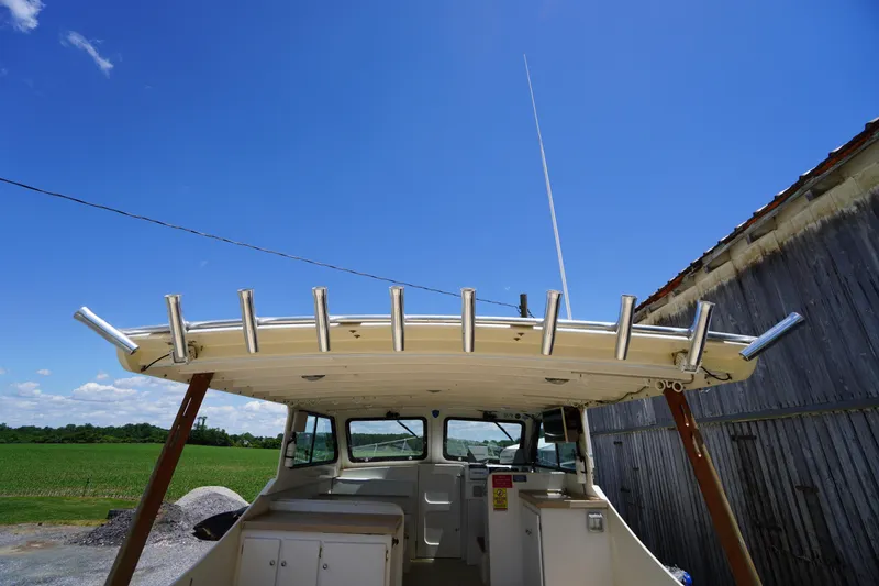 Slide: The Image of 1989 Markley 35 Ft. Deadrise boat with rod holders, under clear blue sky. - 63