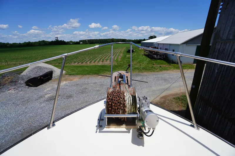 Slide: The Image of Bow view of 1989 Markley 35 Ft. Deadrise boat with anchor chain, farmland background. - 65