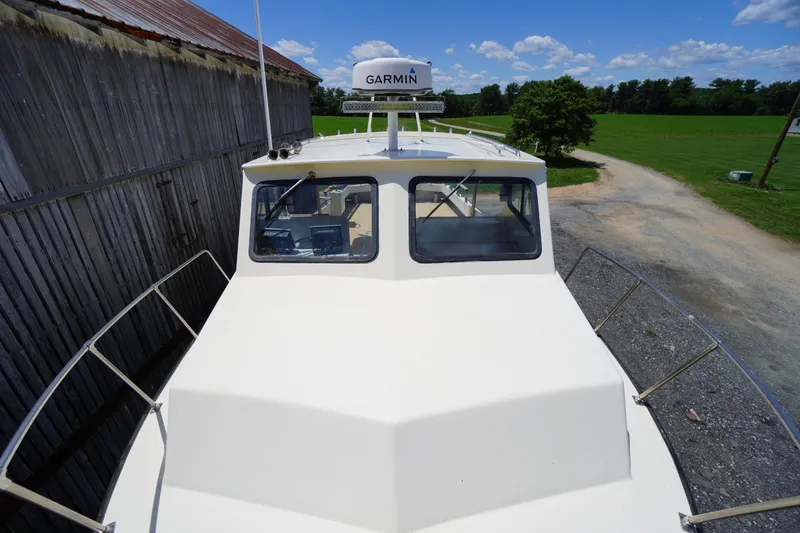 Slide: The Image of 1989 Markley 35 Ft. Deadrise boat with Garmin equipment, docked near a rustic barn. - 66